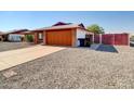 Front view of a brick house with an orange garage door at 10329 W Griswold Rd, Peoria, AZ 85345