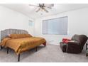 Spacious bedroom with gray headboard and large window, and a relaxing armchair at 12105 W Luxton Ln, Avondale, AZ 85323