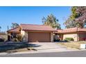 Tan stucco house with brown garage door and desert landscaping at 12234 S Shoshoni Dr, Phoenix, AZ 85044