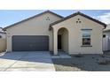 Tan house with brown garage door, front entrance, and small landscaping at 13151 E Verbina Ln, Florence, AZ 85132