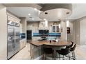 This gorgeous kitchen boasts stainless steel appliances, a dark tiled backsplash, and a functional island at 1457 E Copper Holw, Queen Creek, AZ 85140