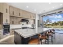 Modern kitchen with large island, high-end appliances, and golf course view at 17444 N 79Th St, Scottsdale, AZ 85255