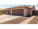 House exterior showcasing a three-car garage and brick pathway at 17925 W Mauna Loa Ln, Surprise, AZ 85388