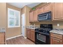 Kitchen with brown cabinets, black appliances, and granite countertops at 2331 W Kristina Ave, San Tan Valley, AZ 85144