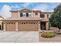 Two-story house with tan exterior, three-car garage, and desert landscaping at 2551 E Saratoga St, Gilbert, AZ 85296