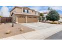 Two-story house with tan exterior, three-car garage, and desert landscaping at 2551 E Saratoga St, Gilbert, AZ 85296