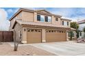 Two-story house with tan exterior, three-car garage, and desert landscaping at 2551 E Saratoga St, Gilbert, AZ 85296