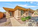 Front view of a tan house with a walkway and neatly trimmed bushes at 41604 N Cedar Chase Rd, Anthem, AZ 85086