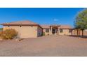 Single-story home with Spanish-style architecture, gravel driveway, and mature trees at 44429 N 1St Dr, New River, AZ 85087