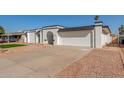 Exterior view of a single-story house with a two-car garage and a neatly landscaped yard at 5919 S Lakeshore Dr, Tempe, AZ 85283