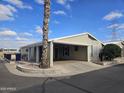 Tan mobile home with carport and mature palm tree in front at 650 N Hawes Rd # 4820, Mesa, AZ 85207