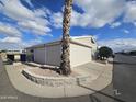 Tan mobile home with carport and roll-up garage door at 650 N Hawes Rd # 4820, Mesa, AZ 85207