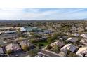 An aerial view of the neighborhood with a clubhouse, green spaces, and desert landscaping at 7654 E Quill Ln, Scottsdale, AZ 85255