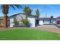 Mid-century modern home with a landscaped front yard, featuring a unique design element at 8626 E Montebello Ave, Scottsdale, AZ 85250