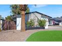 Mid-century modern home with a side yard featuring a unique design element and gate at 8626 E Montebello Ave, Scottsdale, AZ 85250