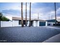 Updated single story home with gravel landscaping and a navy blue garage door at 941 W Peralta Ave, Mesa, AZ 85210