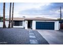 White brick house with a blue garage door and landscaped front yard at 941 W Peralta Ave, Mesa, AZ 85210