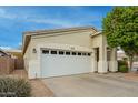 Tan house exterior with a white garage door and landscaping at 9862 E Flower Ave, Mesa, AZ 85208