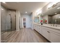 Beautiful bathroom with a walk-in shower, dual sinks, modern fixtures, and a spacious walk-in closet at 14200 W Village Pkwy # 113, Litchfield Park, AZ 85340