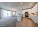 Modern kitchen featuring white cabinets, stainless steel appliances, a breakfast bar, and stylish tile backsplash at 14200 W Village Pkwy # 113, Litchfield Park, AZ 85340