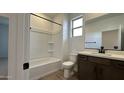 Modern bathroom with a shower/tub combo, dark vanity, and tile floor at 15797 W Hackamore Dr, Surprise, AZ 85387