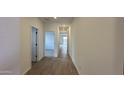 Bright hallway with light wood-look tile floors and doors to other rooms at 15797 W Hackamore Dr, Surprise, AZ 85387