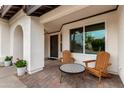 Inviting front patio with two wooden armchairs and a decorative table at 16032 N 46Th Pl, Phoenix, AZ 85032