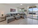 Gray sectional sofa and ottoman in living room with backyard access at 17403 W Eagle Ct, Goodyear, AZ 85338