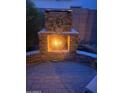 Stone outdoor fireplace with decorative wreath detail providing a cozy backyard ambiance at 17673 W Agave Rd, Goodyear, AZ 85338