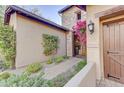 Welcoming entryway with a charming wooden door and beautiful landscaping at 17918 N 95Th St, Scottsdale, AZ 85255