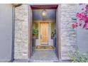Elegant front door entrance with stone detailing and a wood door at 17918 N 95Th St, Scottsdale, AZ 85255