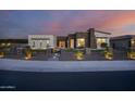 Stunning curb appeal! This modern home features a two-tone exterior and landscape lighting at 23311 N 95Th Dr, Peoria, AZ 85383