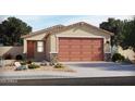 Tan house with brown garage door and landscaping at 3244 E Hayden Rose Ave, San Tan Valley, AZ 85143