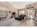 Spacious living room with vaulted ceiling, dark brown sectional sofa, and tile floors at 6872 W Linda Ln, Chandler, AZ 85226