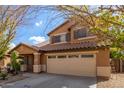 Two-story house with tan exterior, two-car garage, and landscaping at 835 E Marigold Pl, San Tan Valley, AZ 85143