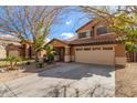 Two-story house with tan exterior, two-car garage, and landscaping at 835 E Marigold Pl, San Tan Valley, AZ 85143