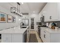 White kitchen with island, stainless steel appliances, and pantry at 10994 W Mckinley St, Avondale, AZ 85323