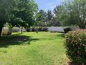 Lush backyard featuring mature trees, vibrant bushes, picnic table and white picket fence at 2207 W Hayward Ave, Phoenix, AZ 85021