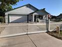 Inviting single-story home with a well-kept lawn, featuring a white picket fence and attached garage at 2207 W Hayward Ave, Phoenix, AZ 85021