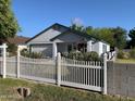 Charming single-story home featuring a white picket fence, manicured shrubs, and a well-maintained front yard at 2207 W Hayward Ave, Phoenix, AZ 85021
