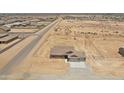 Aerial view of new home construction and its desert landscape in a neighborhood with paved roads at 22270 W Skinner Rd, Wittmann, AZ 85361