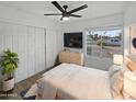 Cozy bedroom with white sliding doors, a ceiling fan, and a large window at 3005 S Pennington --, Mesa, AZ 85202