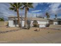 Single story home with desert landscaping and two palm trees at 4102 E Blanche Dr, Phoenix, AZ 85032