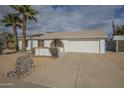 Front view of a single-story home with a large driveway and desert landscaping at 4102 E Blanche Dr, Phoenix, AZ 85032