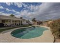 Kidney shaped pool with concrete decking in a backyard setting at 4102 E Blanche Dr, Phoenix, AZ 85032