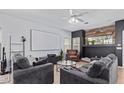 Living room featuring a large screen, comfy seating, and a fireplace at 44783 W Alamendras St, Maricopa, AZ 85139
