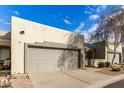 Exterior view of two tan stucco homes with gray garage doors at 64 N 63Rd St # 3, Mesa, AZ 85205