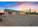 Contemporary desert home with brick driveway, exterior lighting, modern garage doors and desert landscaping at 8110 E Saddle Horn Rd, Scottsdale, AZ 85255
