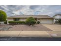 House exterior showcasing a well-maintained front yard and driveway at 10027 W Concord Ave, Sun City, AZ 85351