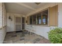 Inviting front porch with tiled flooring, small table and chairs, and security door at 10027 W Concord Ave, Sun City, AZ 85351